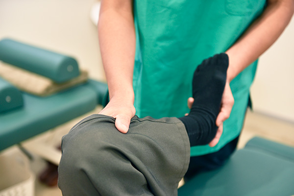 脚のストレッチ施術を受ける男性